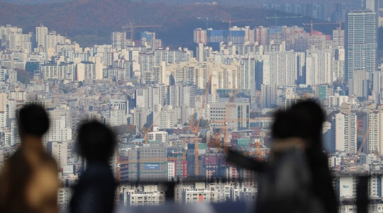 시민들이 서울 시내 아파트 밀집 지역을 바라보고 있다. <연합뉴스>